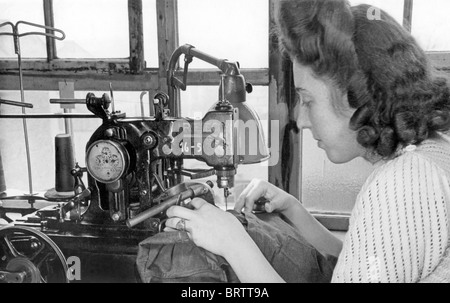 Donna cucito su una macchina da cucire, immagine storica, ca. 1952 Foto Stock