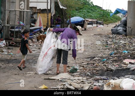 Cambogia Soun Thouch Srey (42) e suo figlio Khoeun Sovan (8) passeggiate in discarica per la ricerca di materiali riciclabili Foto Stock