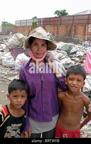 Cambogia Scavenger Soun Srey con figli Khoeun Sovan (8) e Khoeun Sanja (10), vicino a Phnom Penh Caeay Media garbage dump. Foto Stock