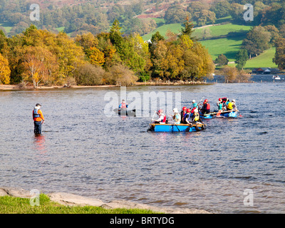 Giovani adolescenti sotto la supervisione durante l'acquisizione di esperienze sul Coniston Water su zattere improvvisate Foto Stock