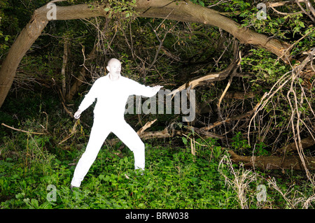 Alien uomo in bianco luminoso con vestiti catturati in una fitta foresta infestata da erbacce Foto Stock