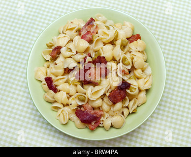 La pancetta e mini shell forme di pasta con cremosa salsa di piselli Foto Stock