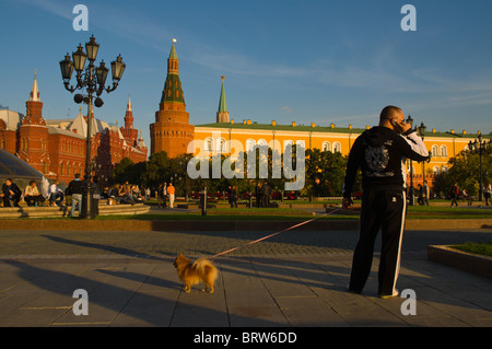 Uomo con un cane parlando al telefono mobile a ploshchad Manezhnaya Square accanto alla centrale del Cremlino di Mosca Russia Foto Stock