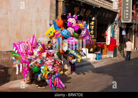 Strada cinese venditore a vendere palloncini in Jianshui, Cina Foto Stock