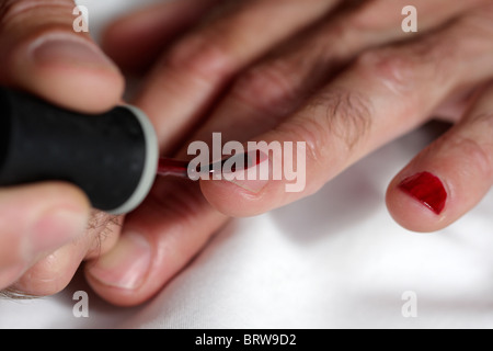 L'uomo opera il suo dito unghie Foto Stock