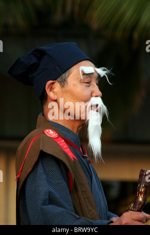 Un uomo dal Giappone è che indossa un finto bianco di baffi e barba durante il Festival di Honolulu parade di Honolulu, Hawaii. Foto Stock