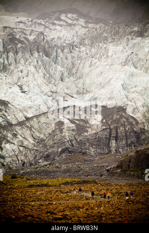 La gente a piedi nella parte anteriore del massiccio muro glaciale Foto Stock