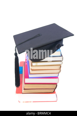 Student hat su una torre fatta di libri, contro uno sfondo bianco - concetto di istruzione Foto Stock