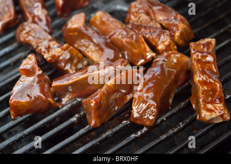 Carni bovine barbecue costolette di cottura su un grill all'aperto in estate Foto Stock