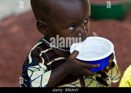 Un giovane ragazzo di bere da un bicchiere. Foto Stock