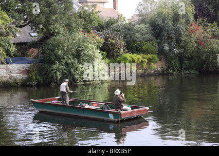 Due uomini in un fondo piatto in barca sul fiume Avon in Christchurch eventualmente per la pesca del salmone. Foto Stock