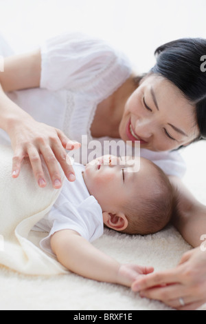 Madre Guarda Baby Boy Sleeping Foto Stock