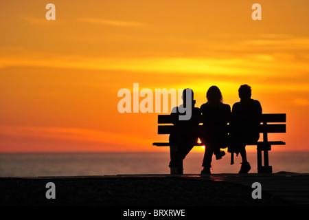 Persone su una panchina sul lungomare a guardare il tramonto, SOMME (80), Piccardia, Francia Foto Stock