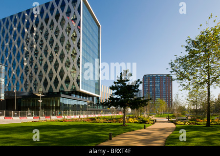 Edificio MediaCityUK 'Orange' (Università di Salford) dall'area 'The Green' della piazza. Salford Quays, Manchester, Regno Unito. City Lofts appartamenti dietro. Foto Stock