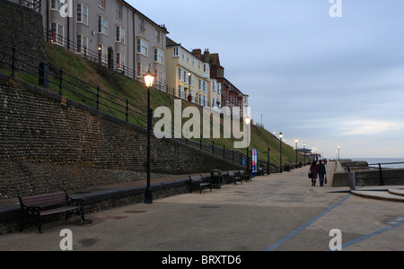 La gente camminare lungo la passeggiata a Cromer in prima serata. Foto Stock