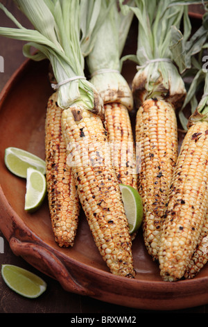 Arrostite sulla pannocchia di mais e limes nel recipiente Foto Stock