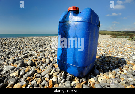 Un contenitore di plastica di perdite di olio e degli inquinanti di una remota spiaggia ghiaiosa Foto Stock