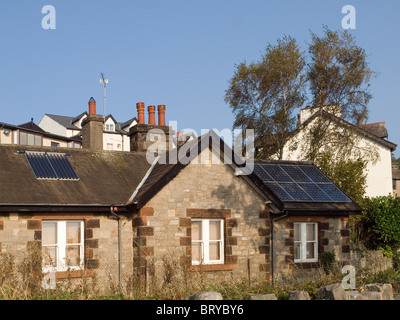 Riscaldamento acqua e Photo Voltaic potenza elettrica la generazione di pannelli solari sul tetto di casa a Grange Over Sands Cumbria Foto Stock