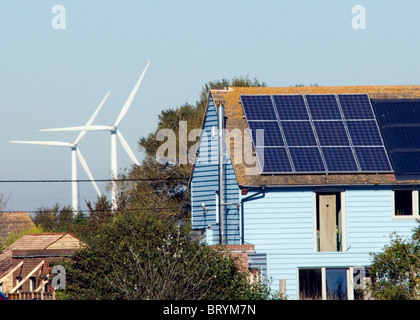 Le turbine eoliche dietro una casa con pannelli solari la casa riciclata Camber Segala East Sussex Foto Stock