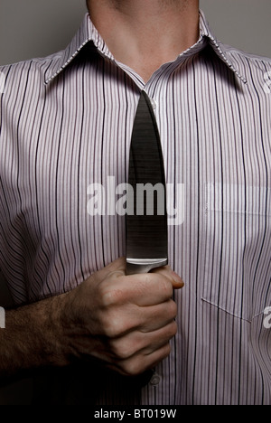 Close-up di uomo con coltello a petto in un modo minaccioso Foto Stock