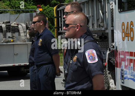 Prince George County vigili del fuoco stand presso l'attenzione come un funzionario di polizia i funerali passa la loro posizione in Landover, Maryland Foto Stock