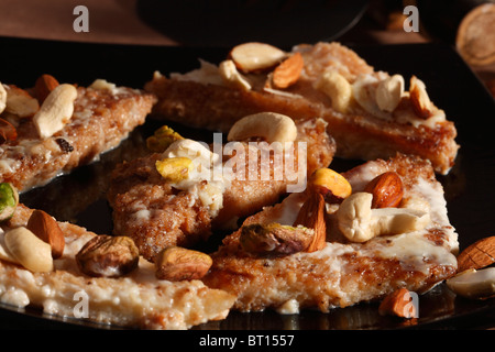 Shahi tukda è preparato con profonda pane fritto nel ghee, guarnite con crema di latte zuccherato e frutti secchi. Foto Stock