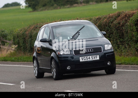 Nero audi automobile che viaggia lungo una strada di campagna inglese. Foto Stock