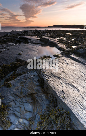 Il sole comincia a salire oltre Kilve beach, nel Somerset (Inghilterra, Regno Unito). Durante la bassa marea l'impressionante la geologia della spiaggia è rivelato Foto Stock
