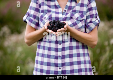 Una donna azienda appena raccolto more, all'aperto Foto Stock