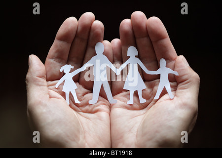 Carta famiglia catena protetti in mani a tazza Foto Stock