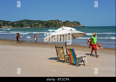 Un fornitore di spiaggia passeggiate lungo la spiaggia di Geriba Buzios Foto Stock