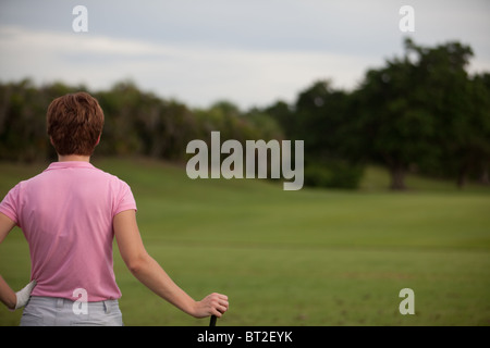 Giocatore di golf femminile guarda verso il corso Foto Stock