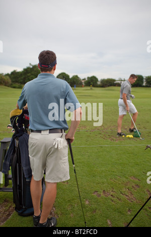 Due golfisti maschio sul driving range. Foto Stock