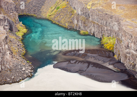 Vicino alla cascata di Dettifoss, pulire la molla di acqua che è stata filtrata attraverso la lava si mescola con glaciale acqua allo stato fuso Foto Stock