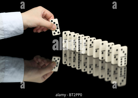 Domino osso in mano su sfondo nero Foto Stock