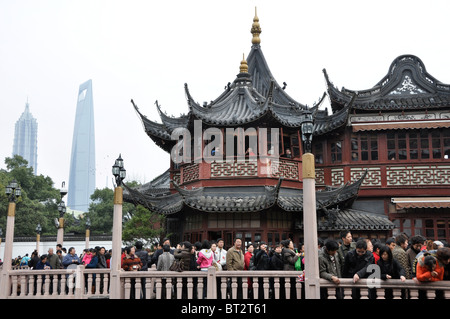 La folla di turisti presso i Giardini di Yuyuan con torre Jinmao e il centro finanziario torre in background in Cina Shanghai Foto Stock