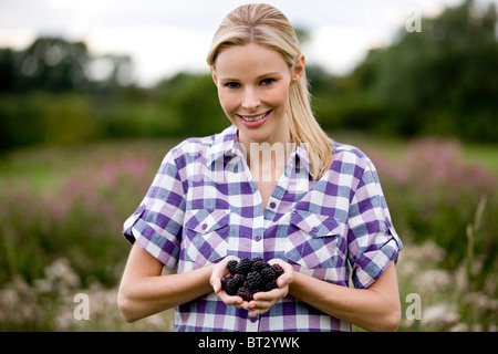 Una donna azienda appena raccolto more, all'aperto Foto Stock