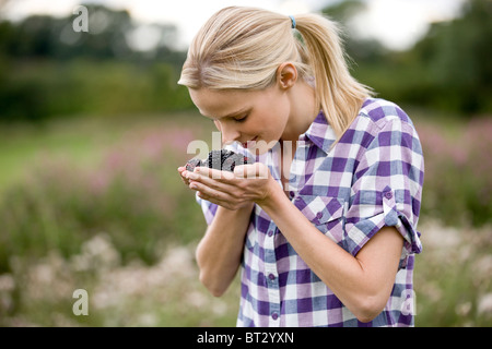 Una donna azienda appena raccolto more, all'aperto Foto Stock