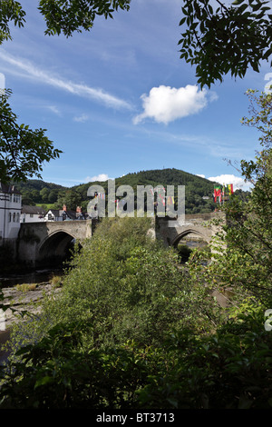 Llangollen road bridge decked out in bandiere su un bel inizio autunno giornata con l'alberato hilltop in distanza. Foto Stock