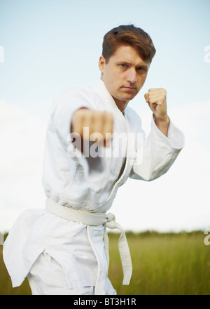 Il giovane uomo è impegnato nel karate open-air Foto Stock