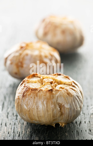 Close up di carni arrosto bulbi di aglio Foto Stock