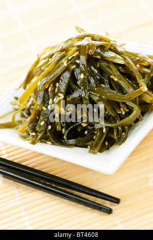 Piastra di alghe wakame salad con bacchette Foto Stock