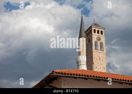 Sahat Kula Clock Tower, la guglia di Gazi Husrev-beg moschea e il tetto dell'antica Gazi Husrev-begov di Sarajevo Foto Stock