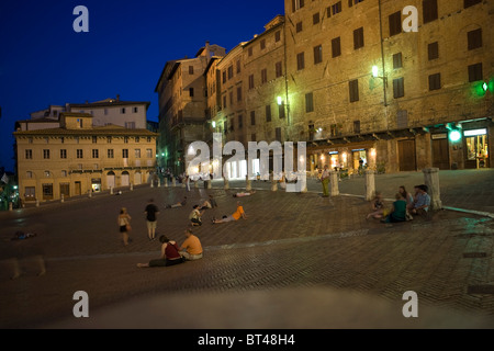 La gente seduta in Piazza del Campo a Siena, Italia Foto Stock