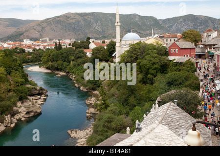 Il fiume Neretva che scorre attraverso Mostar affiancato da Koski Mehmed pasa moschea e la città vecchia di Mostar. Foto Stock