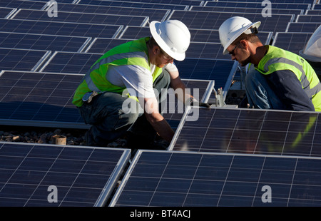 Denver, Colorado - Lavoratori installare pannelli solari fotovoltaici sul tetto di Harrington scuola elementare. Foto Stock