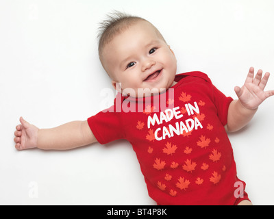 Felice sorridente bambina di quattro mesi ragazzo indossa rosso realizzato in Canada body. Isolato su sfondo bianco. Foto Stock