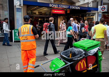 McDonalds pattuglia di lettiera al di fuori di ingresso alla stazione della metropolitana di Bond Street nel centro di Londra Foto Stock