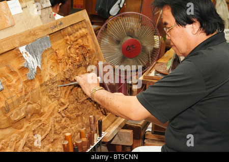 In legno di teak, intagliatore uomo taglio di legno di teak. Bangkok, Thailandia, Settembre 2010 Foto Stock