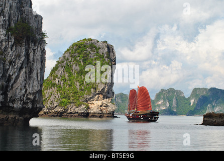 Junk con il red sail tra isole calcaree nella baia di Ha Long, Vietnam Foto Stock
